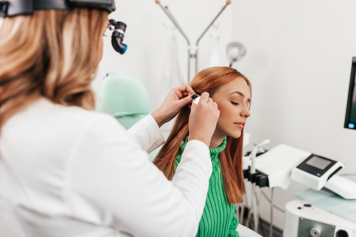 ENT specialist examining a patient ear