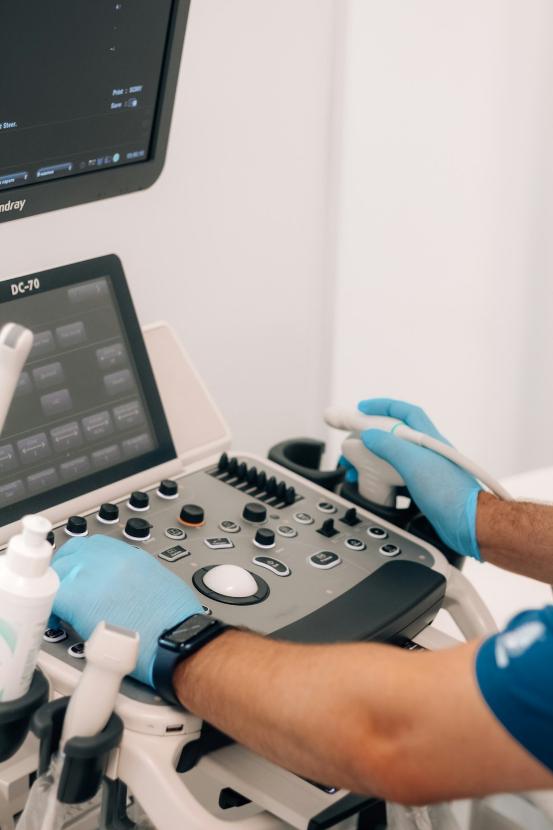person in blue gloves operating a medical machine